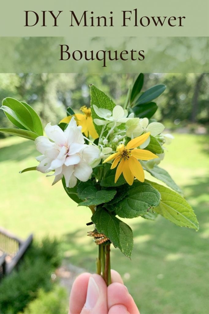 mini yellow and white flower bouquet with hand holding it with a green background