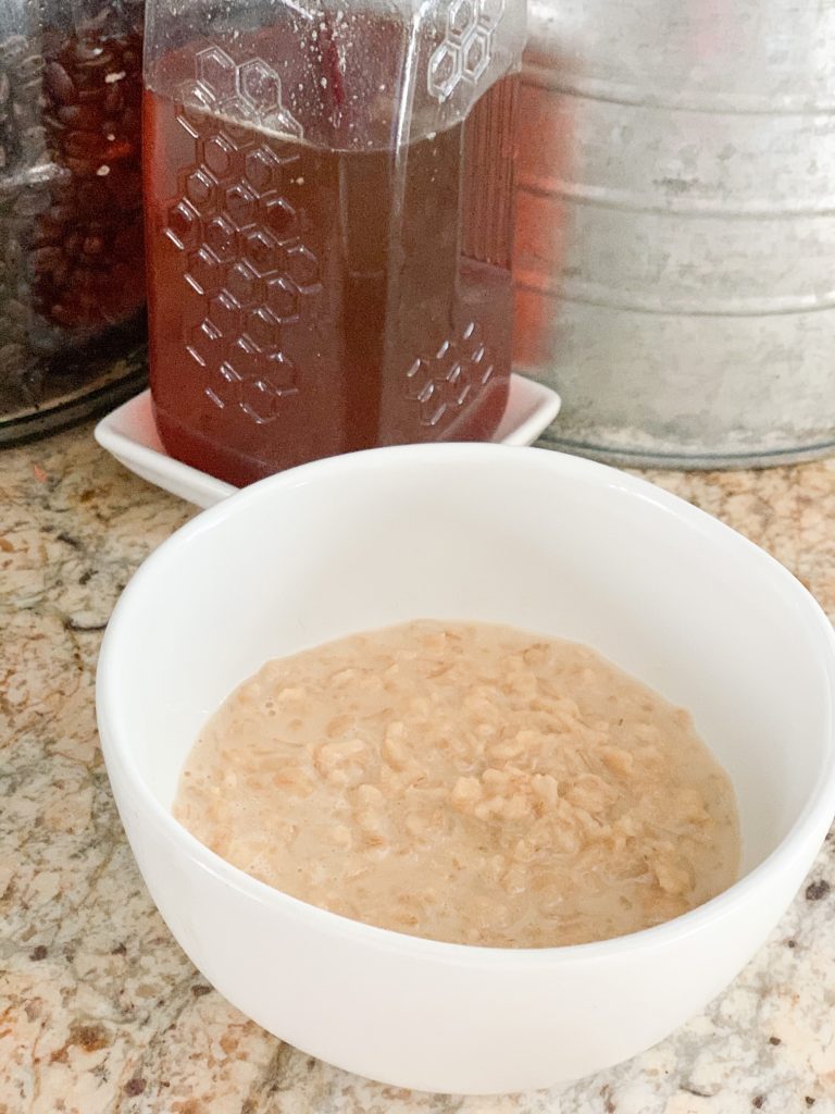 plain oatmeal porridge with honey in the background